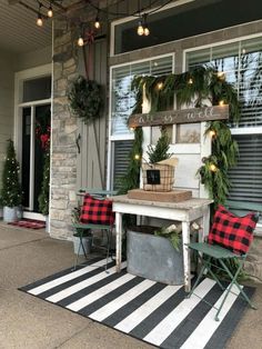 the front porch is decorated for christmas with wreaths and greenery on the table