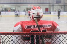 a hockey player is sitting in the goalie's box with his helmet on