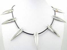 a white necklace with silver spikes on it