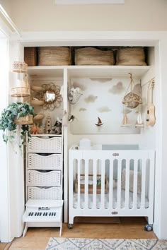 a baby's room with white furniture and baskets on the shelves, including a crib