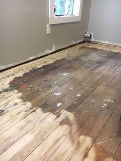 an empty room with wood floors and a window