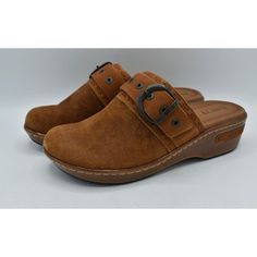 a pair of brown shoes with buckles on the side and two straps at the bottom