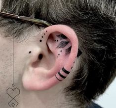 a man with black and white designs on his ears is wearing a pair of ear piercings