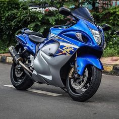 a blue and silver motorcycle parked on the street