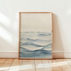 an abstract painting is displayed on the wall next to a wooden floor in front of a white wall