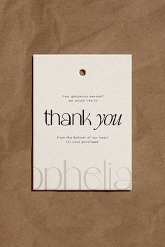 a brown paper bag with a white tag that says thank you