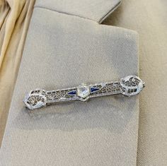 Wear a piece of art from the past with this fanciful floral wirework pin! This is a beautifully made and preserved vintage brooch in 14 karat white gold. A lovely old European cut diamond sits at the center of the brooch and shines bright with innumerable white flashes. Laboratory grown gemstones were a sought after wonder at the time this brooch was made, so the beautifully matched royal blue triangle accents are laboratory grown blue sapphires. The brilliant diamond at the center weighs approx Sapphire Brooch, Floral Filigree, Diamond Color Grade, Star Jewelry, European Cut Diamonds, Vintage Brooch, Brilliant Diamond, Diamond Clarity, Cleaning Jewelry