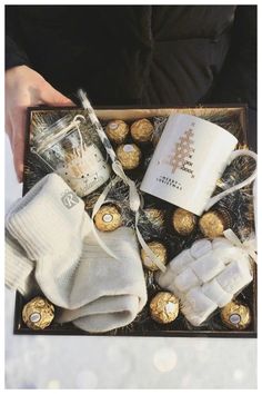 a person holding a box filled with chocolates and socks