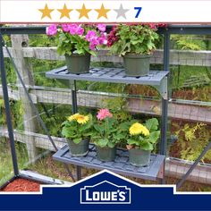 three tiered planter with flowers in pots on the top and bottom shelves below