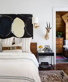 a bedroom with an antelope head mounted on the wall above it's bed