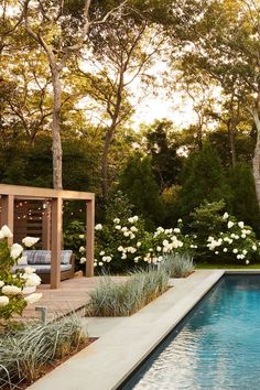 a pool surrounded by white flowers and greenery