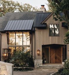 a house that has a lot of windows on the front and side of it,