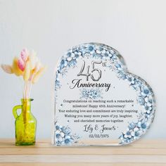 an anniversary plaque with flowers in a vase next to it