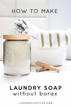 a jar filled with laundry soap next to a wooden spoon and towel on a counter