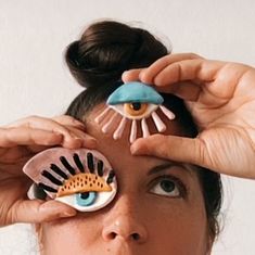 a woman holding up two fake eyeballs to her eyes