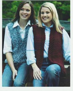 two women sitting next to each other wearing knitted vests