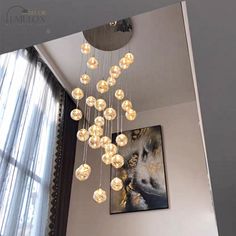 a chandelier hanging from the ceiling in a living room next to a window