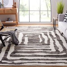 a living room with a white couch and black and white rug