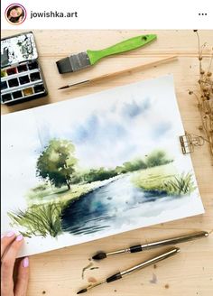 someone is painting a landscape with watercolors