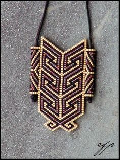 a beaded necklace with an intricate design on it's back end, hanging from a black cord