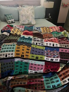 a multicolored quilt on top of a bed