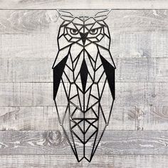 an owl made out of geometric shapes on a wooden wall with wood planks in the background