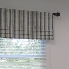 the window is covered with striped roman shades