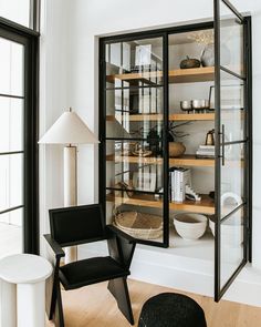 a black chair sitting in front of a glass cabinet