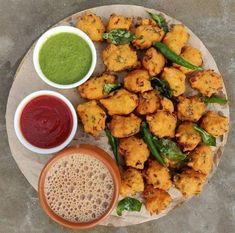 a plate full of fried food with dipping sauces on the side next to it