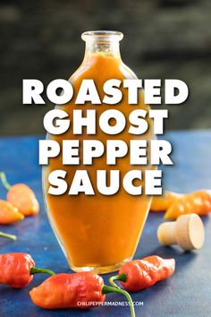 roasted ghost pepper sauce in a glass bottle on a blue table with peppers around it