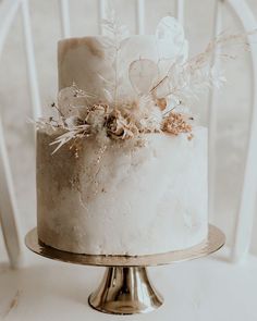 a white cake sitting on top of a metal stand