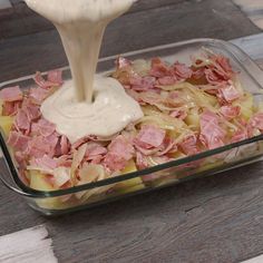 the food is being poured into the casserole dish with ham and cheese on top