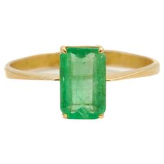 A gorgeous yellow gold vintage emerald cut emerald ring. The natural emerald gemstone has a rich vibrant color and is set in a classic gold band rendered in 18 karat yellow gold. The step cut faceted rectangle green emerald sits along with four soft rounded prongs. Behind the emerald stone the gold frame has an openwork design which ensures optimal light transmission through the stone. Emeralds always gives a mysterious allure. Emerald is a life-affirming stone. It opens the heart chakra and cal Classic Emerald Ring With Baguette Cut, Gold Octagon Solitaire Emerald Ring, Fine Jewelry Emerald Cut Yellow Gold Emerald Ring, Fine Jewelry Gold Emerald Cut Emerald Ring, Gold Solitaire Emerald Ring In Octagon Shape, Gold Emerald Cut Emerald Ring Fine Jewelry, Gold Solitaire Emerald Cut Emerald Ring, Gold Emerald Cut Birthstone Ring, Gold Emerald Cut Ring In Fine Jewelry Style