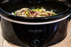 a crock pot is sitting on the counter with food in it's center