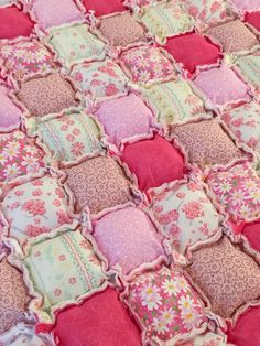 a pink and green patchwork quilt with flowers on it