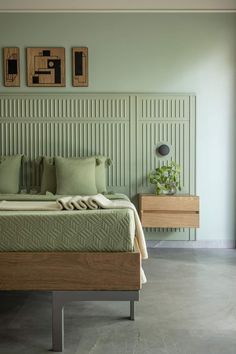 a bed with green sheets and pillows in a room