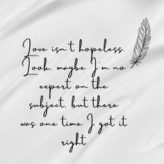 a feather on top of a white sheet with the words love isn't happiness