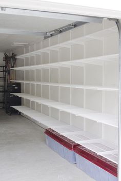 an empty garage filled with lots of white shelves