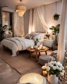 a bedroom decorated in white with candles on the bed and lights hanging from the ceiling