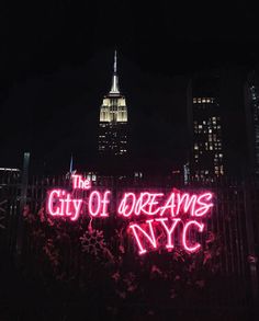 the city of dreams nyc sign is lit up in red and pink neon lights at night