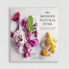 the modern natural dyer book is sitting on a white table with pink and yellow flowers