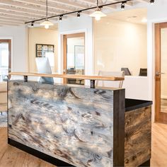 an office with wood flooring and white walls is pictured in this image from the front desk