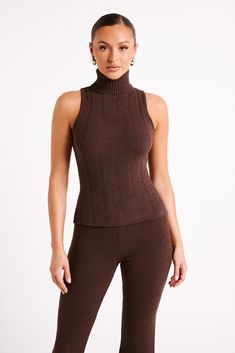 Your other half.ANGELINA is a sleeveless top with a high turtleneck collar and ribbed detail. The knit nylon and elastane fabrication gives it a bodycon fit that’s comfortable and flattering. The neckline is a long, rollover turtleneck that adds visual texture to the otherwise simple, minimalist design. This is a fresh take on a timeless piece and matches perfectly with the Angelina Knit Pants. Ribbed Turtleneck Tank Top, Chic Fitted Knit Mock Neck Top, Chic Stretch Knit Mock Neck Top, Fitted Knit Turtleneck For Layering, Stretch Ribbed Mock Neck Top, Fitted Knit High Neck Turtleneck, Fitted Knit Turtleneck, Fitted Knit Turtleneck With High Neck, Fitted High Neck Knit Turtleneck