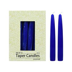 two blue candles sitting next to each other in front of a white box with the words taper candles printed on it