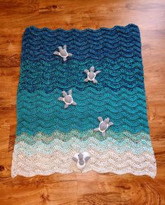 a crocheted blanket with two sea turtles on the bottom and one turtle in the middle