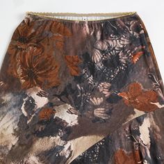 Zanya Asymmetric Maxi Skirt in Brown The Zanya Asymmetrical Hem Floral Midi Skirt is a unique blend of natural elegance and contemporary style. With its intricate floral print and flowing asymmetrical hem, this skirt offers a distinctive look that stands out in any setting. The earthy tones and delicate layers create a sophisticated and graceful silhouette, making it a perfect choice for both casual outings and special occasions. Details: - Intricate floral print for a naturally elegant look- As Chic Skirt With Asymmetrical Hem And Floral Print, Floral Print Flowy Skirt With Asymmetrical Hem, Bohemian Fitted Asymmetrical Maxi Skirt, Chic Asymmetrical Skirt With Floral Print, Flowy Floral Print Skirt With Asymmetrical Hem, Flowy Asymmetrical Wrap Skirt With Floral Print, Fitted Brown Asymmetrical Skirt, Floral Print Flowy Asymmetrical Wrap Skirt, Bohemian Asymmetrical Floral Print Maxi Skirt