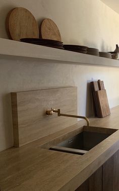 a kitchen with wooden cabinets and shelves above the sink is shown in this image, there are plates on top of the shelf