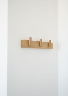 three wooden pegs are hanging on the wall