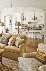 a living room filled with furniture next to a kitchen