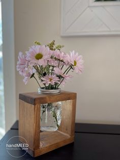 a vase filled with pink flowers sitting on top of a table